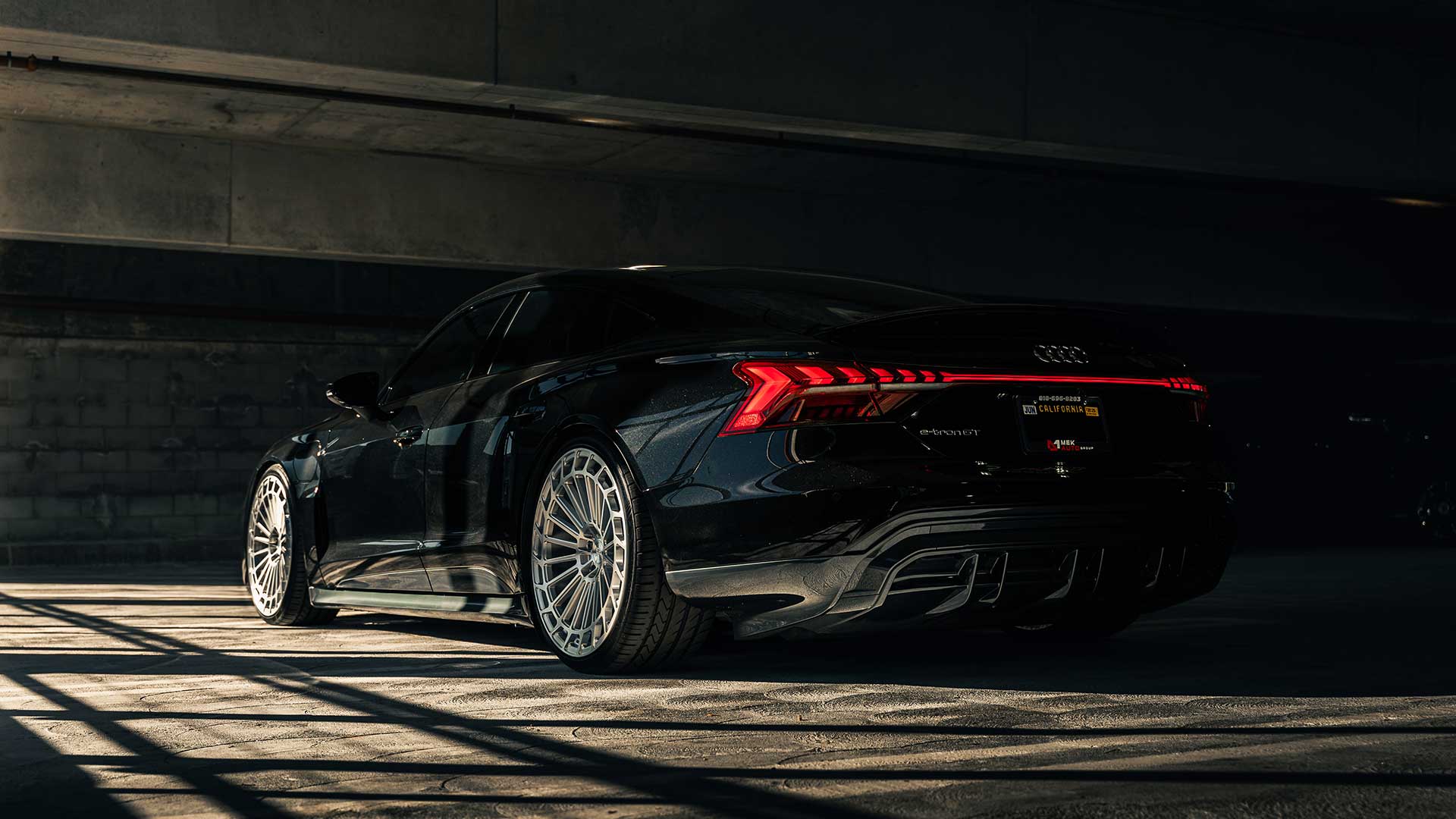 black audi e tron gt with lexani lx twenty tires in dark parking structure