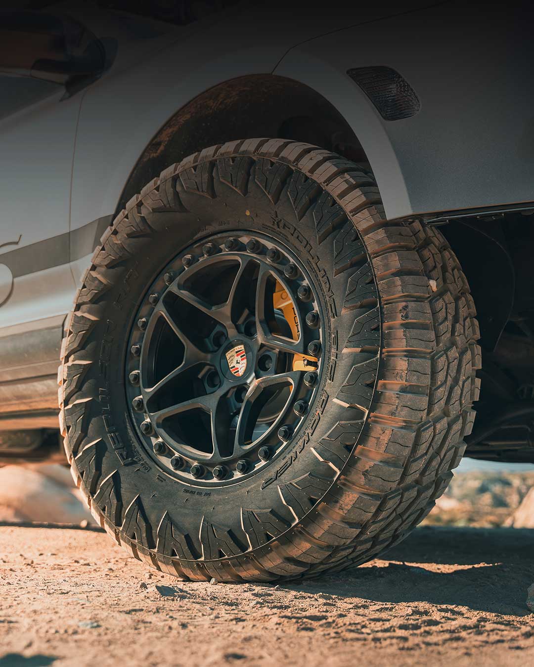 silver off road porsche cayenne with rolling big power repulsor rt tires