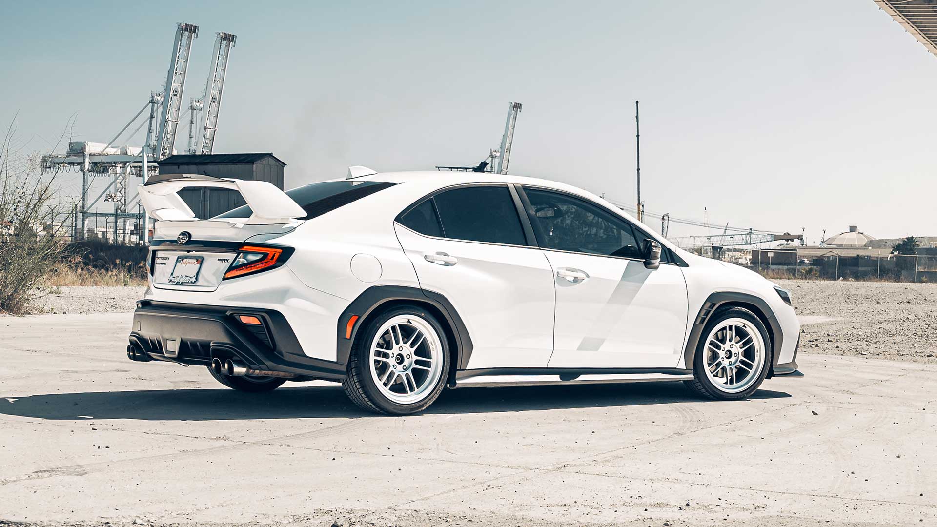 white subaru wrx with lionhart ramani all season tires at industrial port