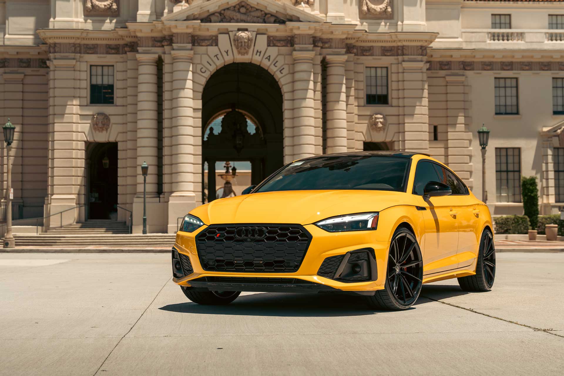 vegas yellow audi s5 b9 with black grille parked in front of pasadena city hall building with stone columns